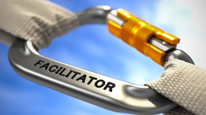 Stylised image of a mountaineer's carabiner with the word 'FACILITATOR' imprinted on the main metal part